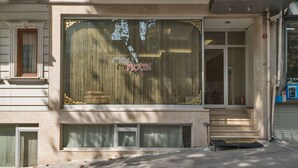 Entrada d'un hotel amb una finestra gran que mostra el nom 'May Hotel'.