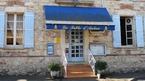 A stone building with a blue awning labeled "La Table d'Antan." - La Table d'Antan (Bon-Encontre)