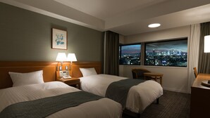 A hotel room with two beds, a desk, a chair, and a large window with a city view. - Toshi Center Hotel Tokyo (Tokyo)
