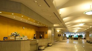 A hotel reception area with a reception desk, a clock, and a sign indicating the room rate. - Toshi Center Hotel Tokyo (Tokyo)
