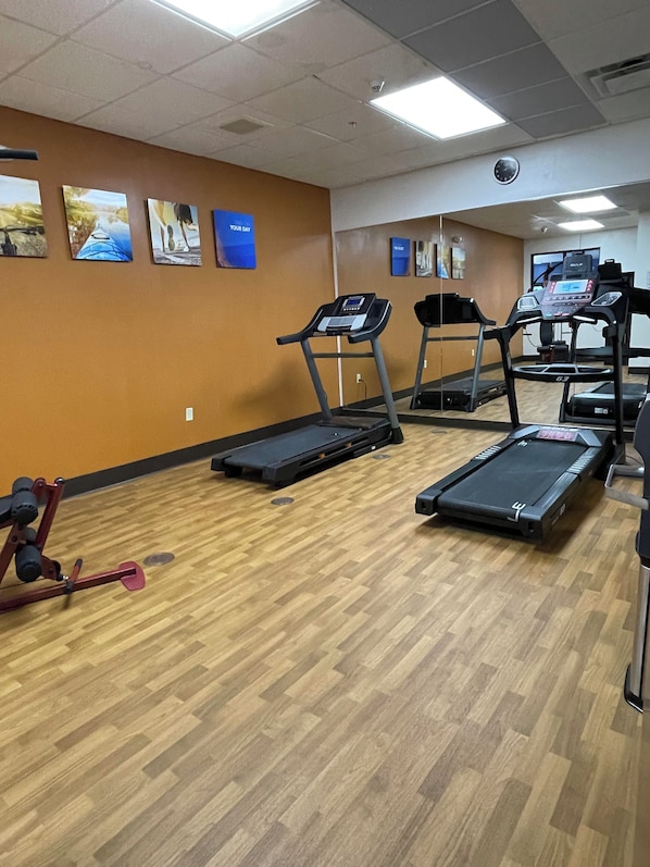 A gym with treadmills, a stationary bike, and a red exercise machine. - Comfort Suites Altoona North (Altoona)