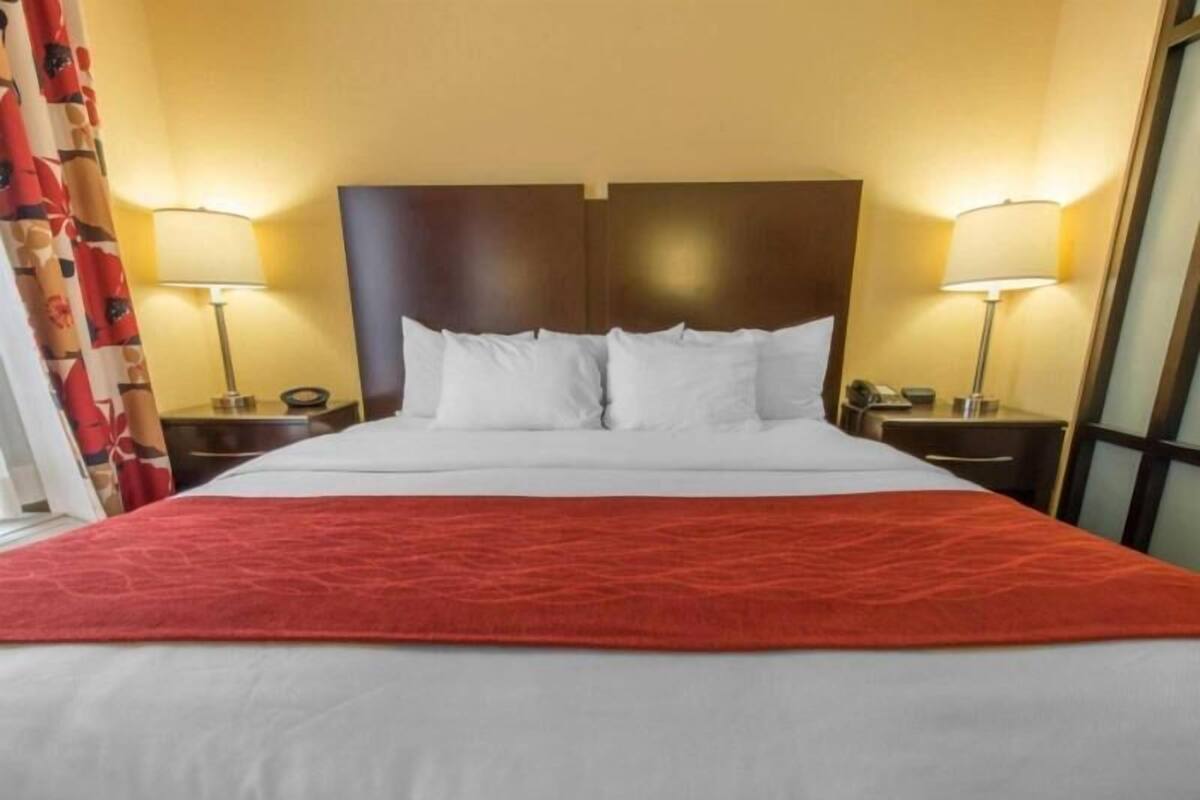 Ein Hotelzimmer mit einem großen Bett, zwei Nachttischen und einem Kopfteil.