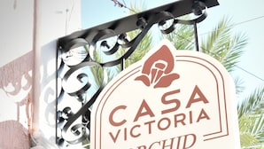 A sign for CASA VICTORIA ORCHID HOTEL, featuring a decorative metal bracket and a clear view of the hotel's name. - Casa Victoria Orchid (Miami Beach)
