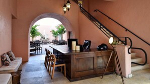 A cozy interior with a wooden bar, seating area, and a staircase. - Casa Victoria Orchid (Miami Beach)