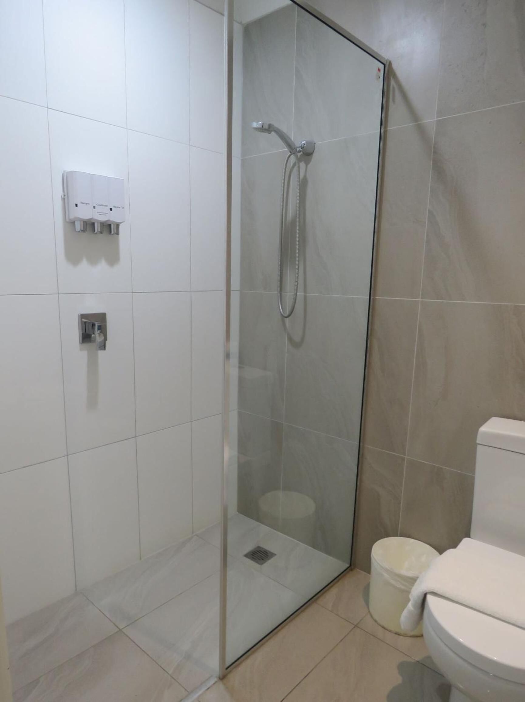Un baño moderno con ducha envuelta en vidrio, un inodoro y un bidé.