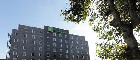 A multi-story building with a Holiday Inn sign, a restaurant named A4 Restaurant, and a parking area.