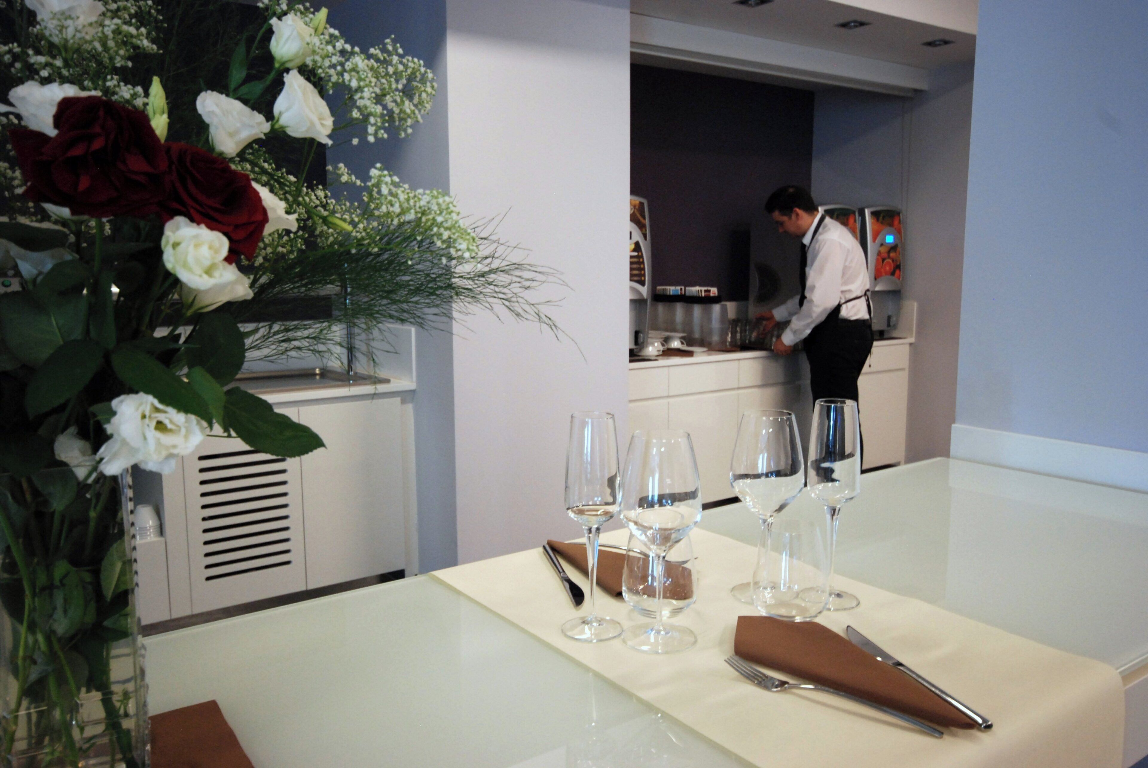 A dining table set with wine glasses and a vase of flowers.
