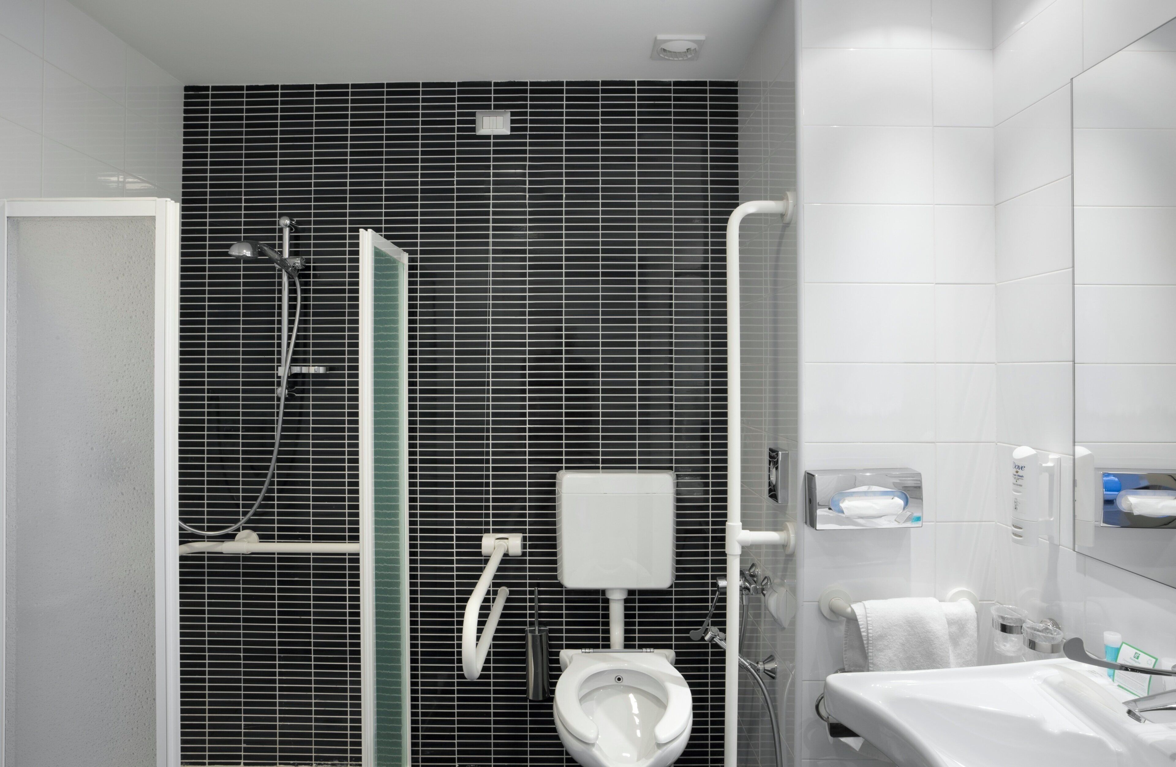 Un baño moderno con ducha, inodoro y lavabo.