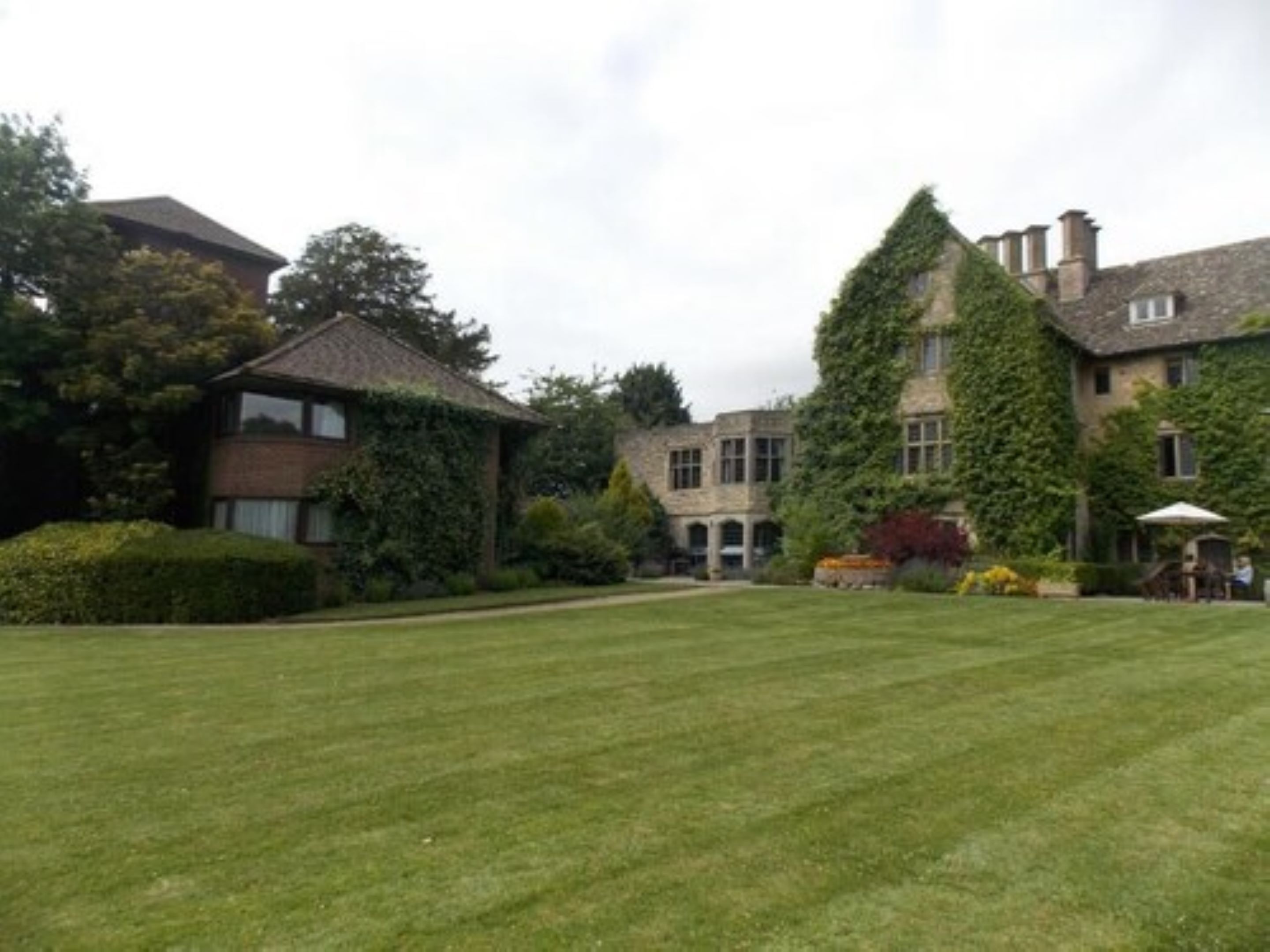 A large, historic building with multiple sections, including a prominent tower and a smaller annex.
