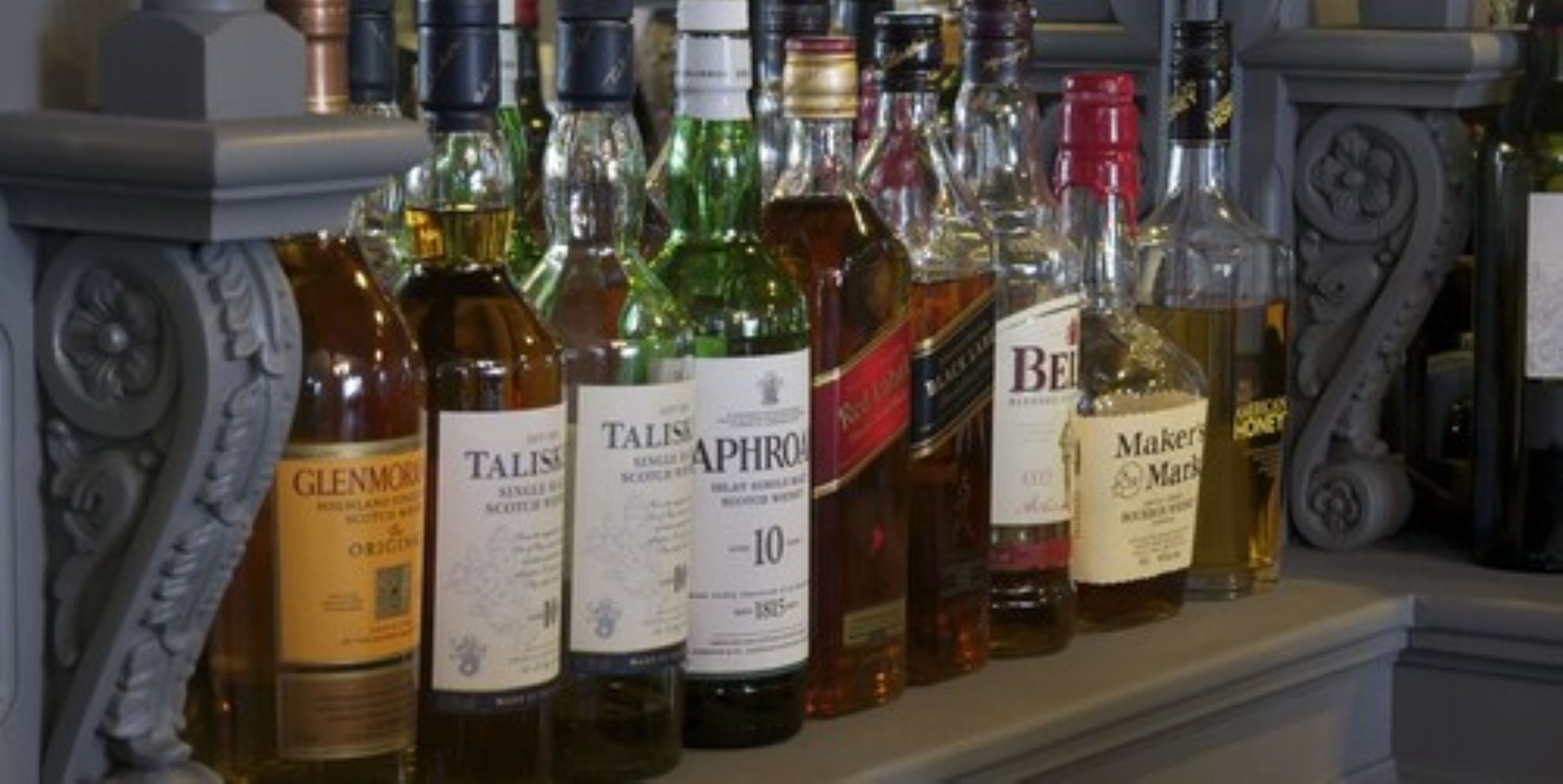 A variety of liquor bottles on a shelf.
