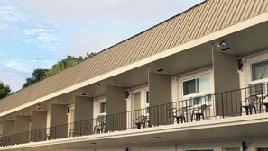 A motel with a flat roof, multiple balconies with railings, and several windows. - M Star Hotel Mansfield (Mansfield)