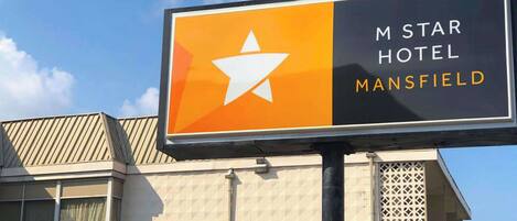 A sign for M Star Hotel Mansfield with a prominent star logo.