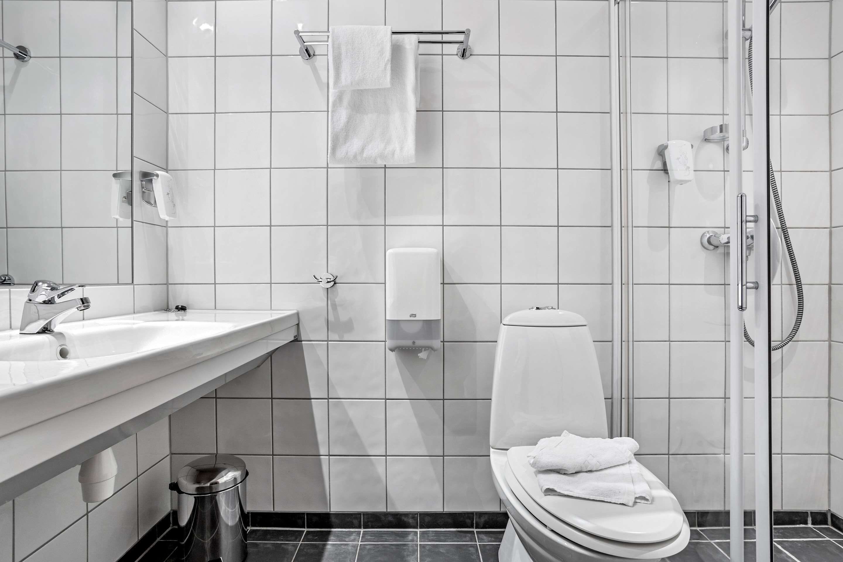 A modern bathroom with a toilet, bidet, and shower.