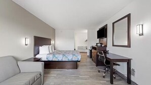 A hotel room with a bed, a desk, a chair, a TV, and a mirror. - Motel 6 Hermison, OR - Umatila (Hermiston)