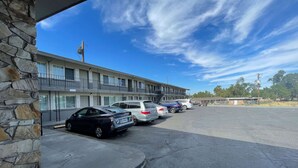 A motel with a row of parked cars and a stone facade. - Motel 6 Hermison, OR - Umatila (Hermiston)