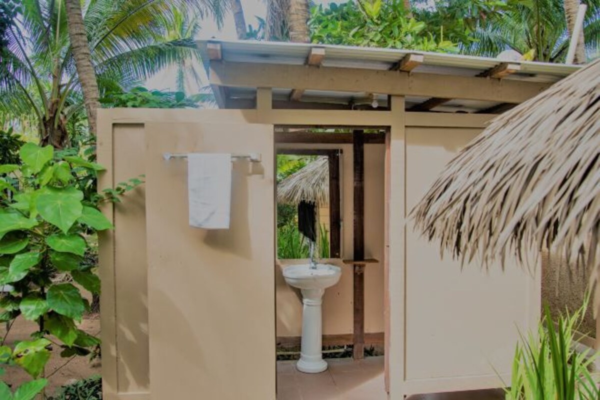 Une petite salle de bain privée avec un lavabo blanc et une serviette accrochée au mur.
