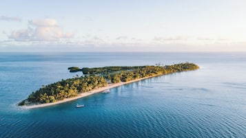 Escape to a serene tropical island with a well-maintained beach and lush surroundings.