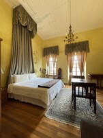 Un dormitorio con una cama grande, una mesa de madera y un candelabro.