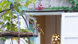 A rustic outdoor setting with a stone wall, a hanging light fixture, and baskets of fruit. - Villa Ketty (Vico Equense)