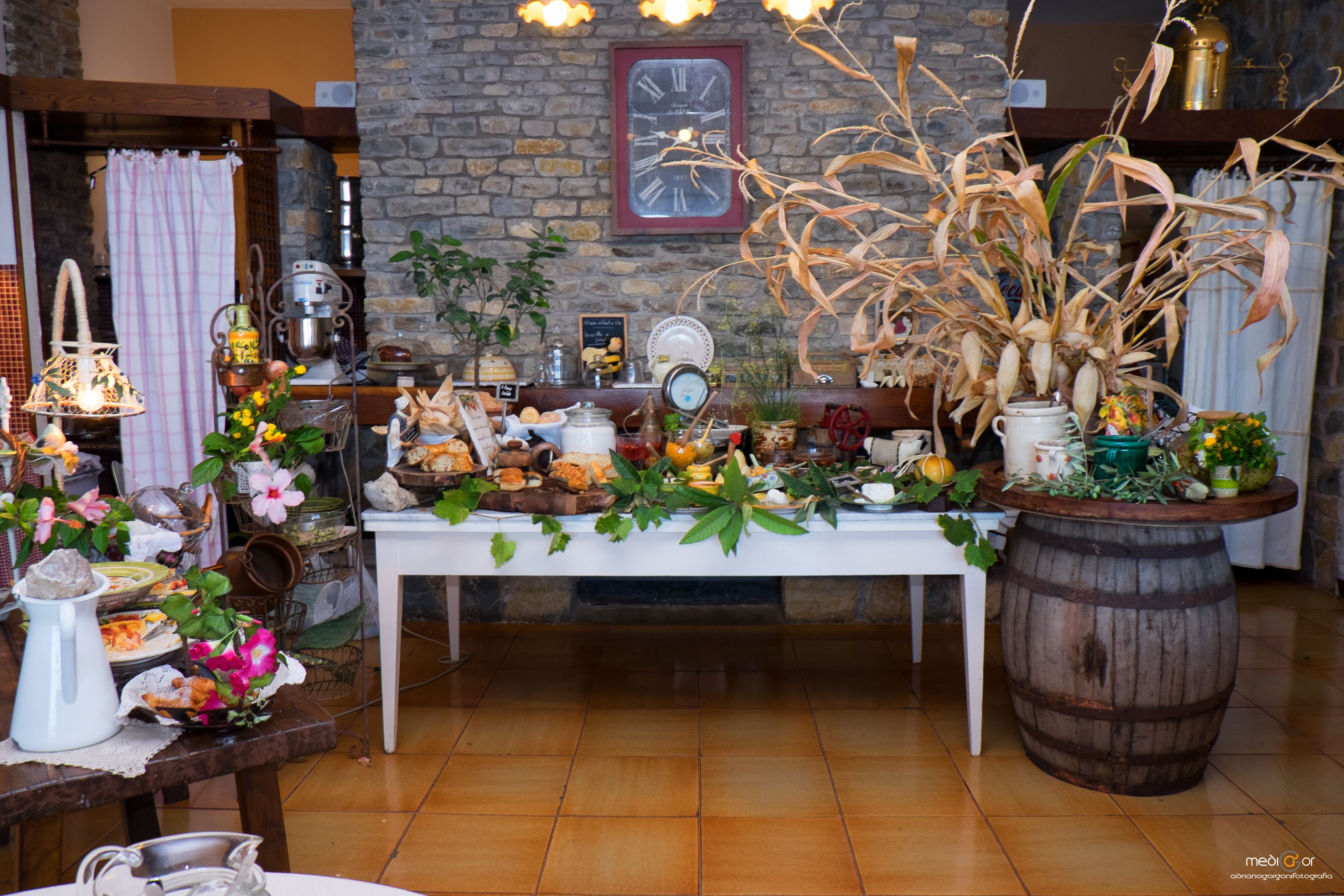 Een rustieke eettafelsetting met een houten tafel, een groot vat, diverse gerechten en decoraties.