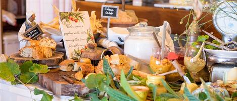 A cheese and wine tasting setup with various cheeses, a wine glass, and a sign indicating 'Il Pane Caldo'.
