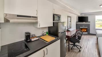A compact kitchen with a microwave, refrigerator, and coffee maker.