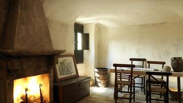 Una habitación rústica con chimenea, muebles de madera y pared de piedra.