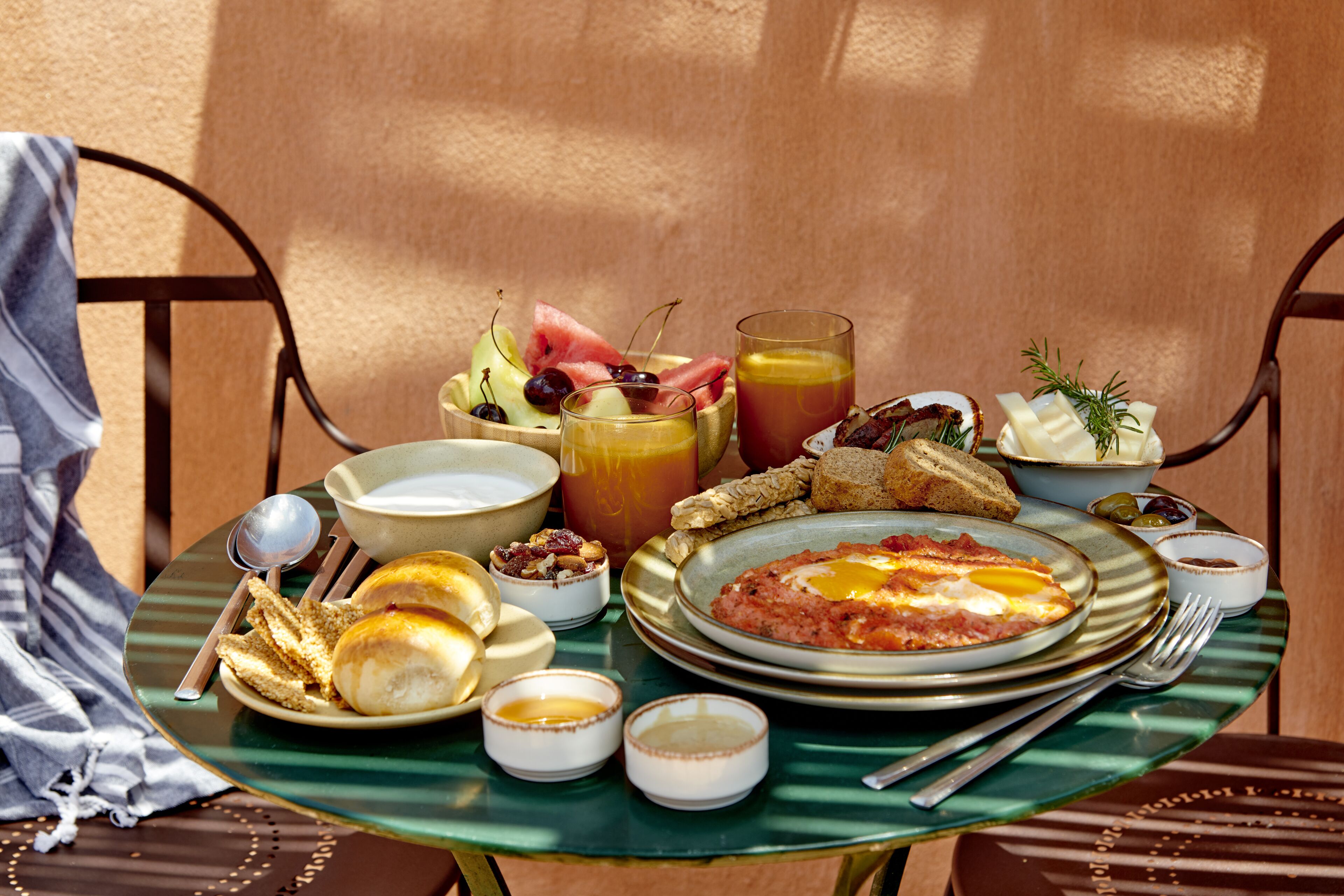 A breakfast table with various dishes, including eggs, toast, and fruit.