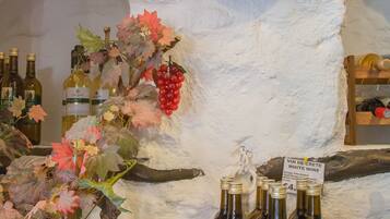 Exhibición de vinos con botellas y parras sobre un muro texturizado.
