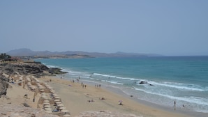 Une plage avec des parasols et des gens.