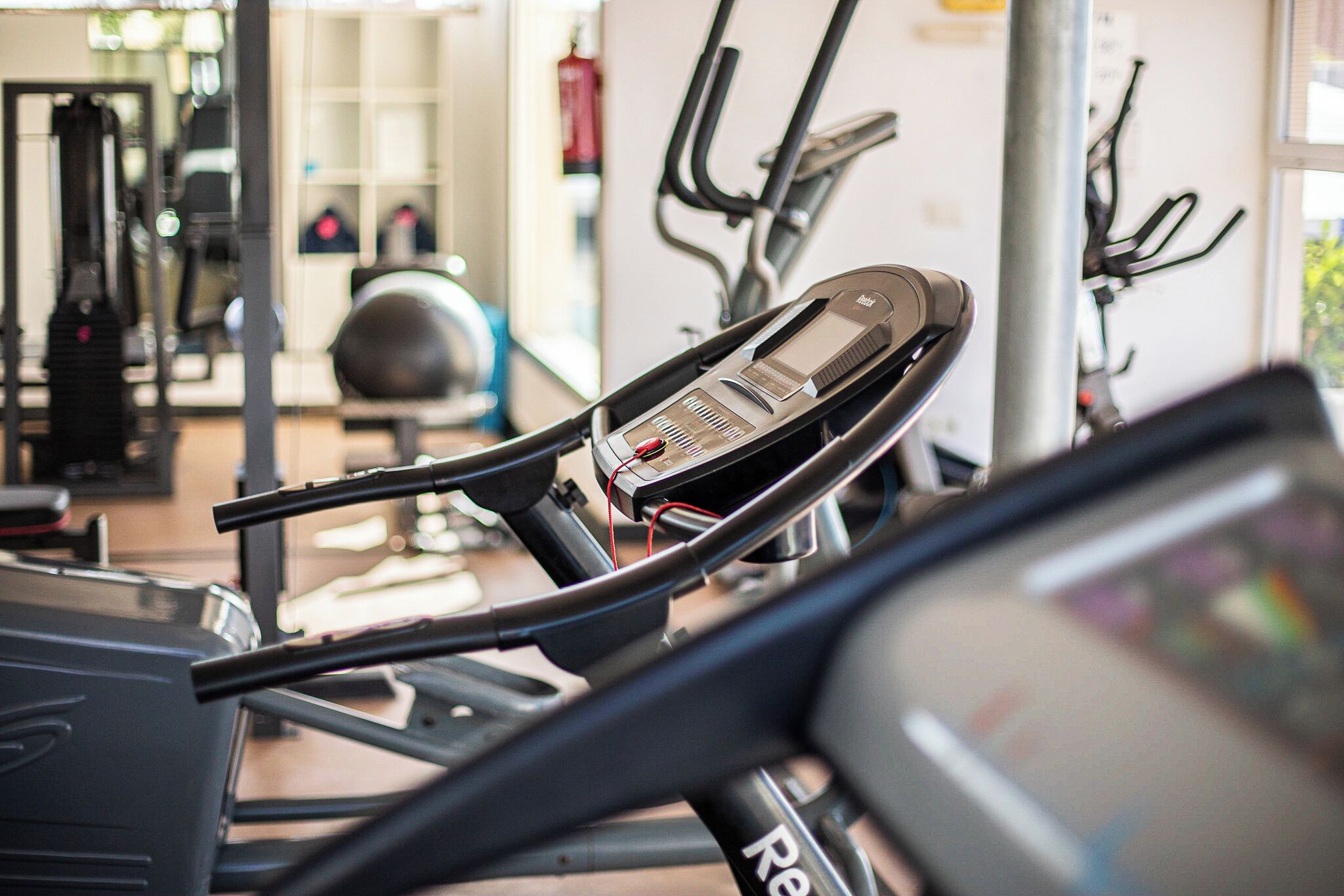A gym with exercise equipment including treadmills and ellipticals.