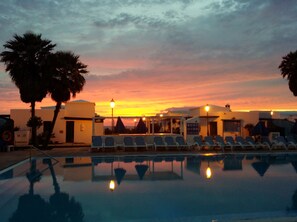 室外游泳池，池畔遮阳伞，日光浴躺椅