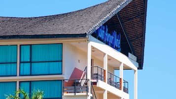 A modern building with a sign reading "Lutong Airport Motel". It features multiple balconies and large windows.