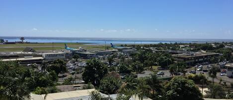 A coastal cityscape with a clear view of the ocean, airport, and various buildings.