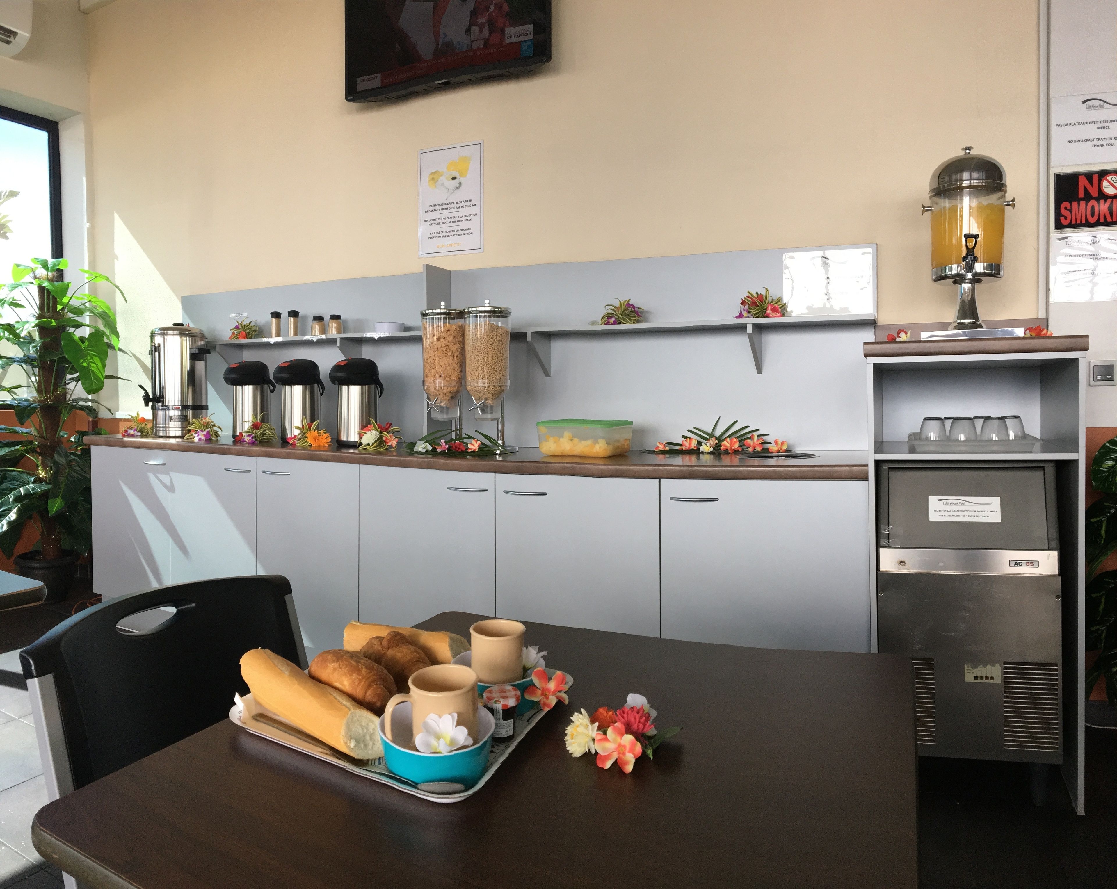 Una disposición para el desayuno con una bandeja de croissants, tazas de café y flores sobre una mesa.