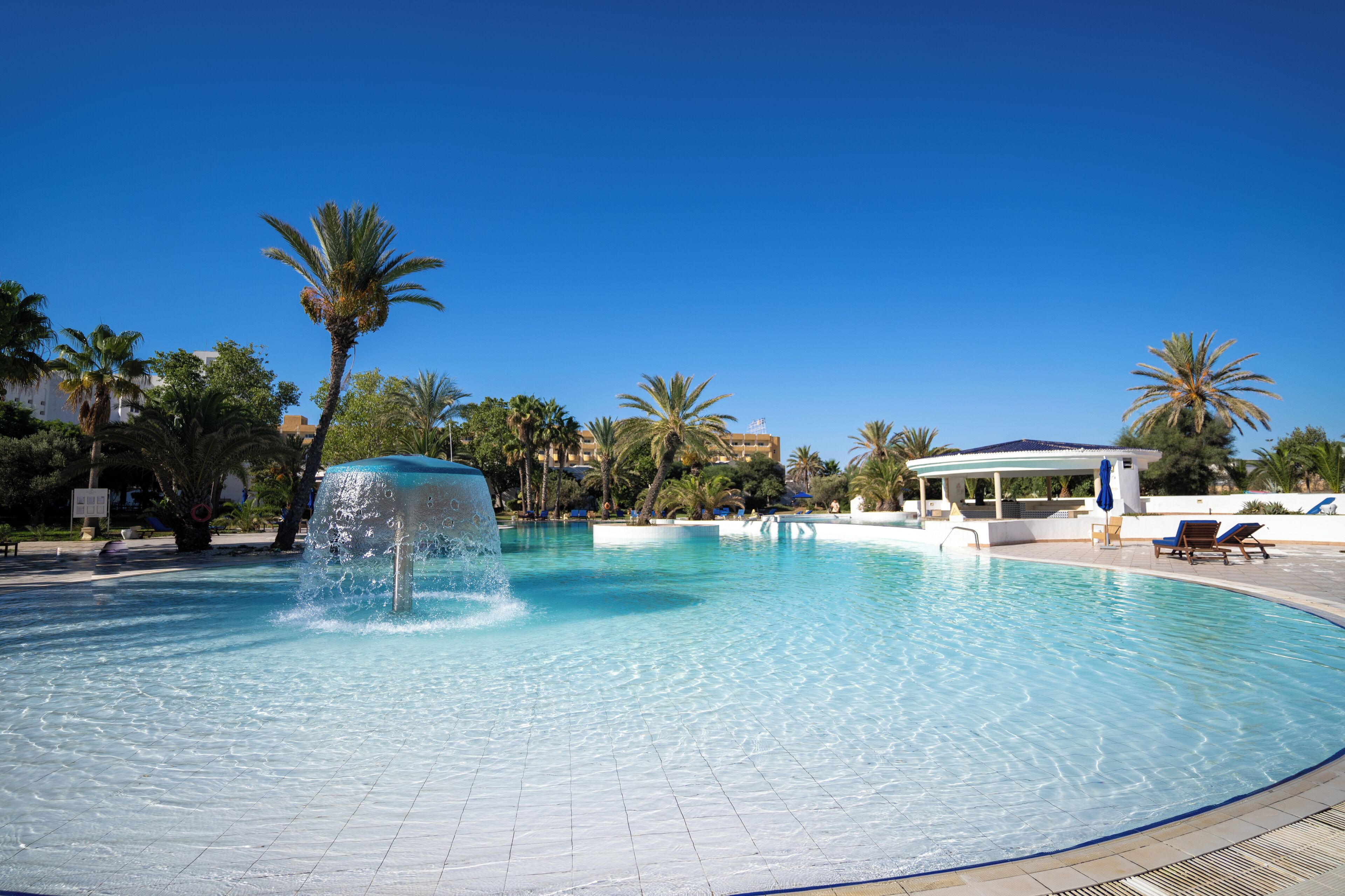 Una piscina cubierta, una piscina al aire libre, tumbonas