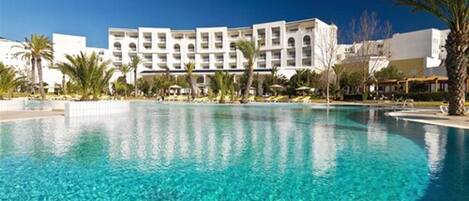 Een binnenzwembad, een buitenzwembad, ligstoelen bij het zwembad