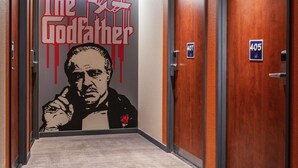 A hallway with a mural of a man in a suit and tie, and the text "The Godfather" with a rose. There are doors numbered 407 and 405. - ibis budget Cannes centre ville (Cannes)