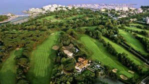 An aerial view of a coastal golf course with multiple greens and a marina in the background. - ibis budget Cannes centre ville (Cannes)