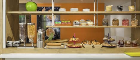 A buffet setup with various food items and condiments.