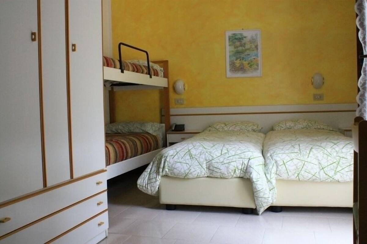 Ein Schlafzimmer mit Etagenbetten, einem Nachttisch und einem Beistelltisch.