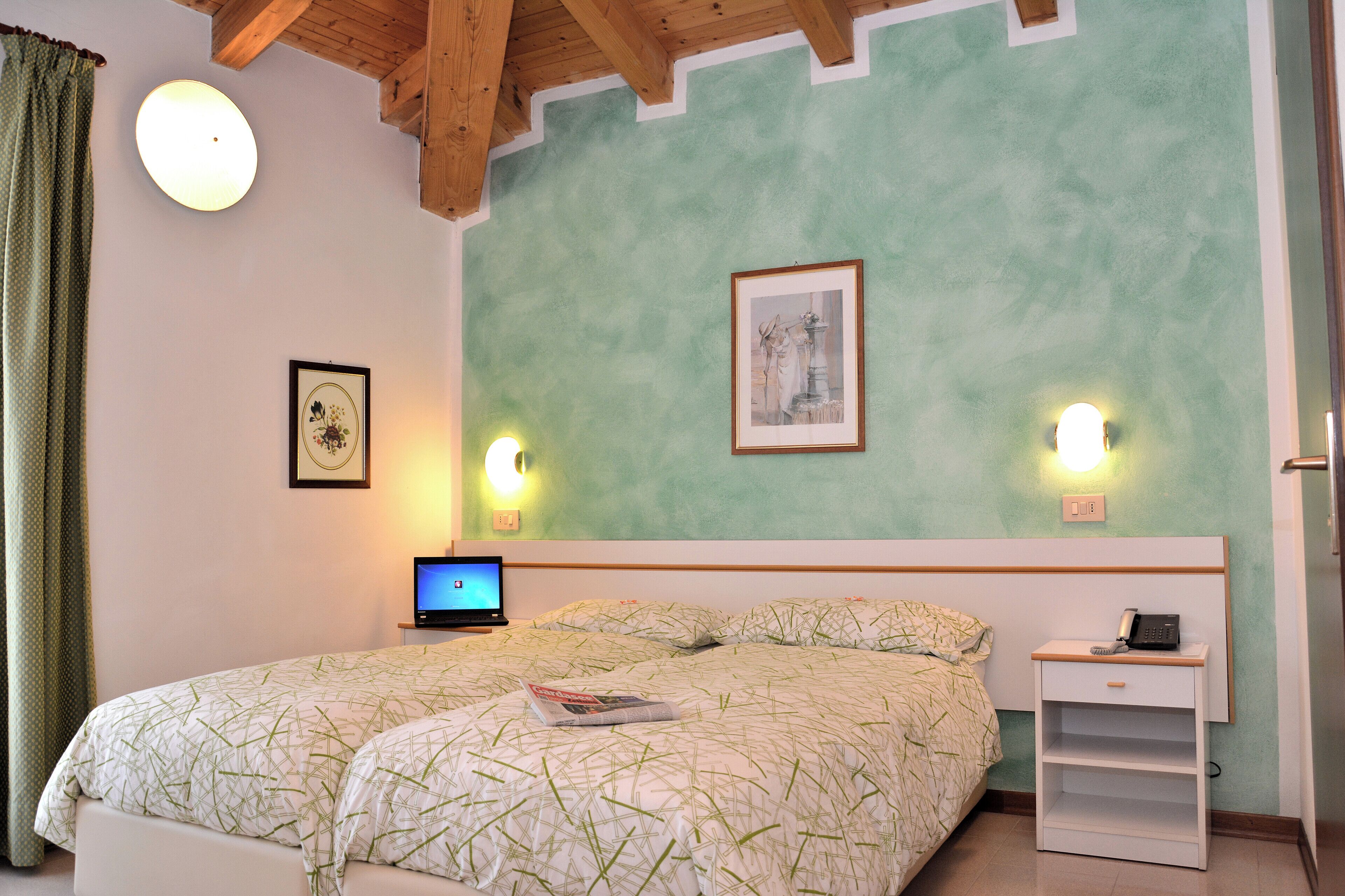 Une chambre à coucher avec un lit, une table de chevet, une lampe et un tableau accroché au mur.