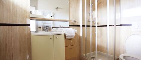 A bathroom with a shower, toilet, and sink.