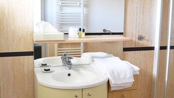 A bathroom with a sink, mirror, towel rack, and a small shelf with toiletries.