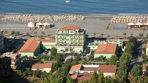 A coastal hotel with multiple floors, a beachside location, and a parking area. - Hotel Germania (Praia a Mare)