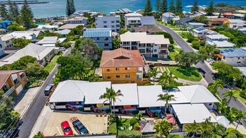 A residential area with houses, a parking lot, and a view of the ocean.