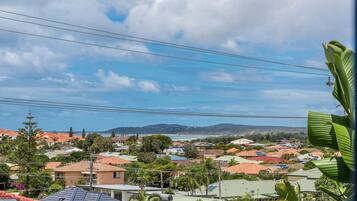 A residential area with houses, power lines, and a distant view of hills.
