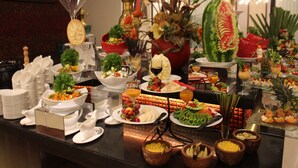 A buffet with various dishes and drinks, including fruits, vegetables, and a large watermelon centerpiece. - Executives Hotel - Olaya (Riyadh)