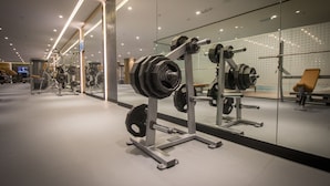 A modern gym with weightlifting equipment and mirrors. - Executives Hotel - Olaya (Riyadh)