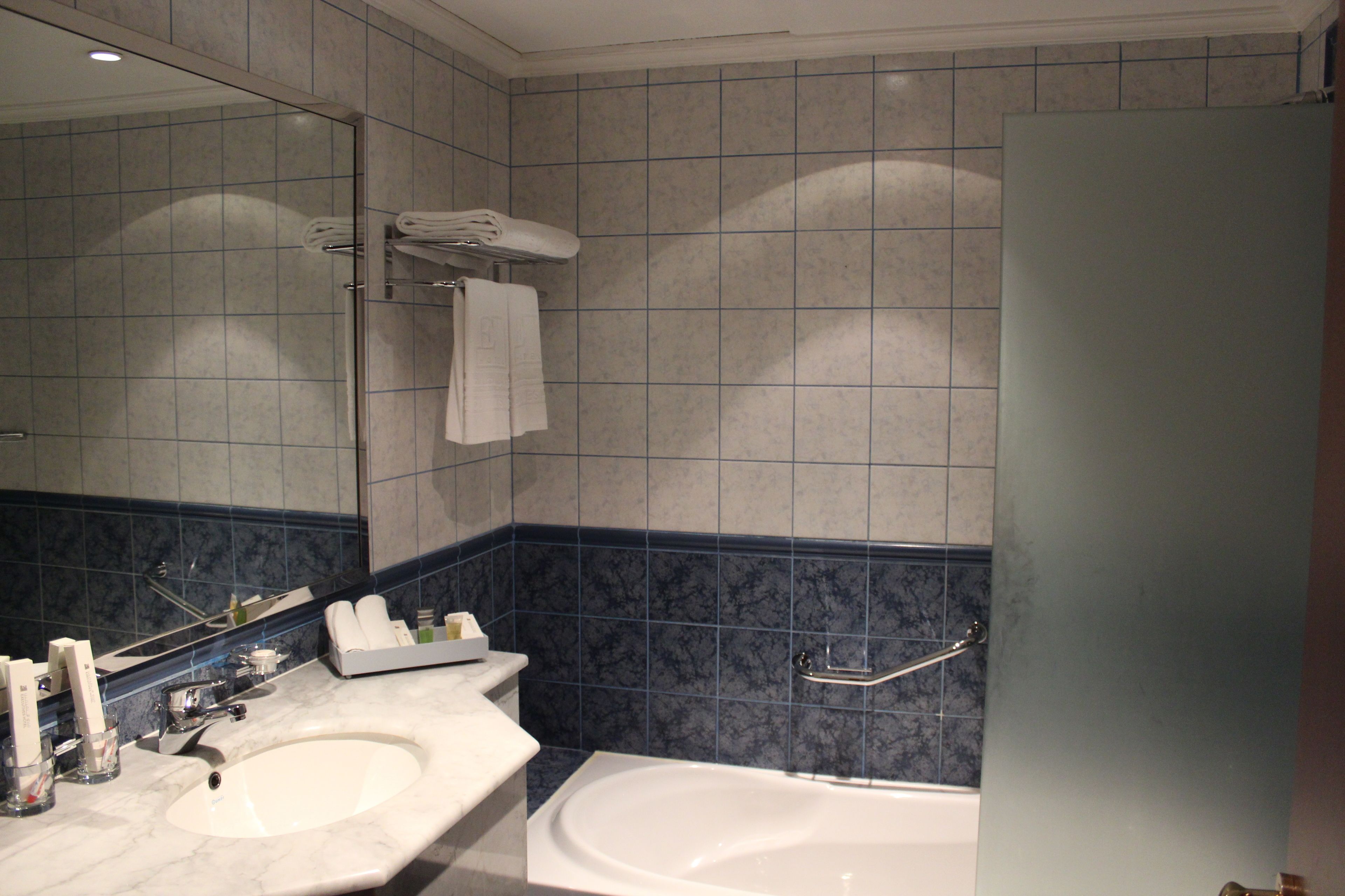 Ein Badezimmer mit Waschbecken, Spiegel und Badewanne.